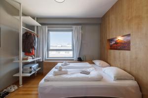 a bedroom with a large white bed with a window at Luci House Boutique Hostel - Vienna 15th district in Vienna