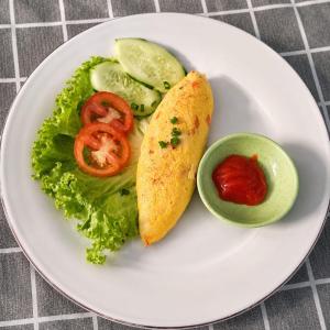 a white plate of food with a omelet and vegetables at Homies Place Tetebatu in Tetebatu