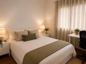 a bedroom with a large white bed with two lamps at Stunning Sea Facing Bayside House with Pool in Birkdale