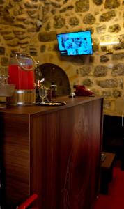 a bar with a tv on a stone wall at Terrace Merdin Konagı in Mardin