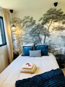 a bedroom with a bed with towels on it at 6 Suites Signature in Saint-Jacques-de-la-Lande