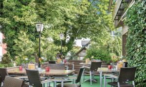 a patio with tables and chairs and trees at Hotel Thüringenschanze in Oberhof