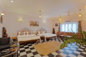 a bedroom with two beds and a checkered floor at Wanderlust A Boutique Homestay in Udaipur