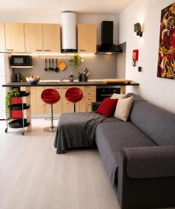 a living room with a couch and a kitchen at Estudio Boho Mar in Praia da Rocha