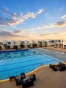 a large swimming pool in a building with chairs at اويسس Oasis in Jeddah +3 photos