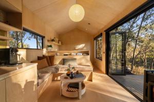 a small living room with a couch and a table at HeartStone Hill - Tiny House in Castlemaine