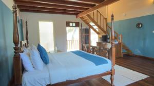 a bedroom with a bed with blue sheets and a staircase at Thambapanni Villa in Unawatuna +13 photos