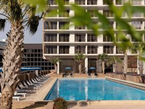 a hotel swimming pool with chairs and a building at Fairmont Dallas in Dallas