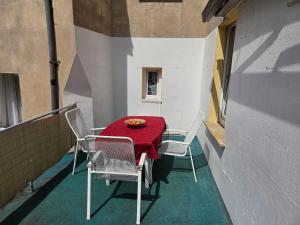 a table and chairs on a balcony with a red table cloth at Monteurwohnungen Santos Lerch in Krefeld