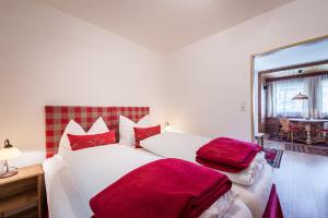 a bedroom with a large white bed with red pillows at Ferienwohnungen Vomperberg in Schwaz