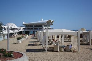 a beach with chairs and umbrellas on the sand at Residenza Nervesa in Lignano Sabbiadoro