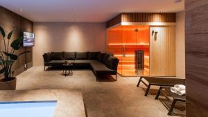 a living room with a black couch and a table at Veluwe Villa with Indoor Pool & Wellness | 12 persons in Wekerom
