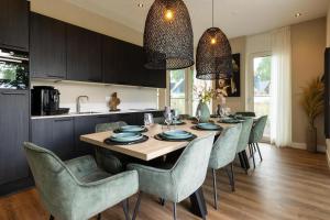 a kitchen and dining room with a table and chairs at Veluwe Villa with Indoor Pool & Wellness | 12 persons in Wekerom