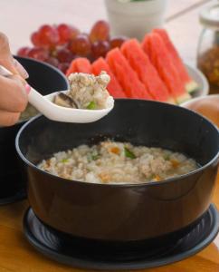 a person is stirring a pot of food with a spoon at Doi Lan Home stay ดอยล้านโฮมสเตย์ in Ban Huai Khai