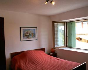 a bedroom with a red bed and a window at L'Auberge Fleurie in Le Nayrac +19 photos