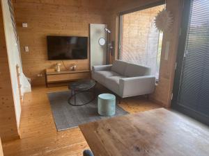 a living room with a couch and a flat screen tv at Ferienhaus an der Wasserkuppe in Poppenhausen