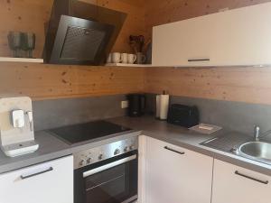 a kitchen with a stove and a microwave at Ferienhaus an der Wasserkuppe in Poppenhausen
