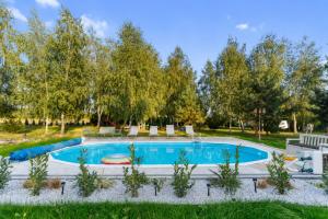 a swimming pool in a yard with trees at "Route 62" Airport Modlin 24h in Goławin
