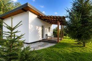 a small white house with a wooden roof at "Route 62" Airport Modlin 24h in Goławin