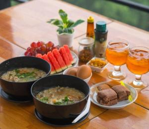 a table with two bowls of soup and bread and drinks at Doi Lan Home stay ดอยล้านโฮมสเตย์ in Ban Huai Khai