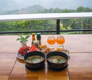 a table with two bowls of food and two glasses of beer at Doi Lan Home stay ดอยล้านโฮมสเตย์ in Ban Huai Khai