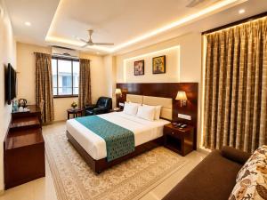 a hotel room with a bed and a couch at Hotel Sai Jashan Shirdi - Where blessings & comfort meet in Shirdi