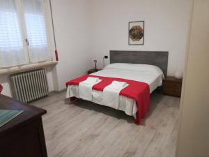a bedroom with a bed with a red and white blanket at APPARTAMENTO LIDA in Lazise
