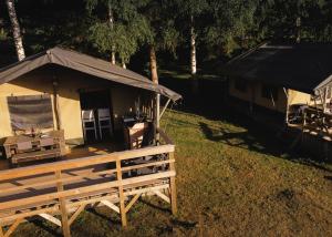 a building with a black tent in the grass at Lodge Holidays - Les Sapins in Camurac