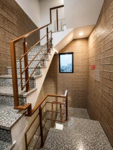 a staircase in a building with a brick wall at crown house in Phagwāra