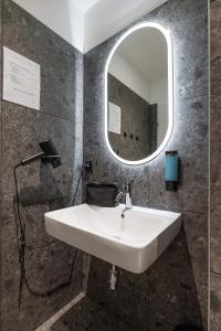 a bathroom with a white sink and a mirror at Luci House Boutique Hostel - Vienna 15th district in Vienna +76 photos