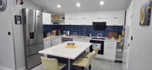 a kitchen with white cabinets and a white table and chairs at Villa View in Neum +15 photos