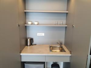 a small kitchen with a sink and shelves at Lucciola Boutique Rooms in Budva