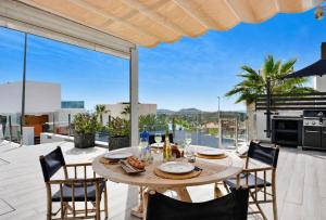 an outdoor dining room with a table and chairs with a view at Hillside Luxury Villas by NRAS in Finestrat