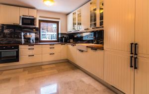 eine große Küche mit weißen Schränken und einem Fenster in der Unterkunft Villa Gastuna in Bad Gastein