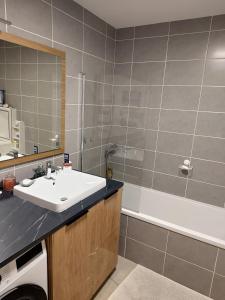 a bathroom with a sink and a bath tub at Modern appartmenr in Bozel