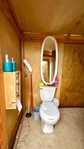 ein kleines Badezimmer mit einer Toilette mit Spiegel in der Unterkunft Solara Glamping in Tecate
