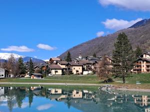 a resort with a lake in front of a mountain at Modern appartmenr in Bozel