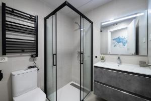 a bathroom with a shower and a toilet and a sink at Getafe Suites in Getafe