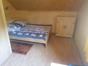 a bedroom with a bed in a wooden room at Domek u Ani 4 in Orelec
