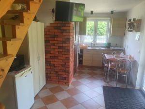 a kitchen with a brick wall and a table with chairs at Domek u Ani 4 in Orelec