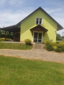 a yellow and green house with a porch at Domek u Ani 4 in Orelec