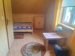 a room with a bed and a table and a window at Domek u Ani 4 in Orelec +10 photos