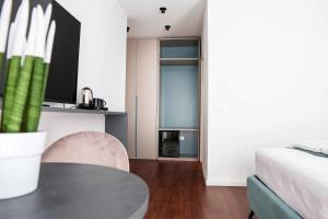 a living room with a table and a bed at Tirone Luxury Rooms in Cirò Marina