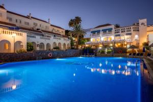 a large blue swimming pool in front of a building at Ona Los Claveles in Los Cristianos