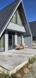 a house with a patio with two chairs and windows at E&T-Cabin A frame in Sibiu