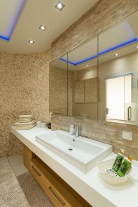 a bathroom with a sink and a large mirror at Royal Luxury Villa by AKTIS VILLAS in Kriopigi +59 photos