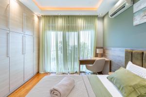 a bedroom with a bed and a desk and a table at Royal Luxury Villa by AKTIS VILLAS in Kriopigi