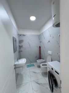 a white bathroom with a sink and a toilet at Angelo Apartments Ilyonis Residence in Shëngjin +20 photos