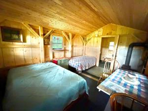 a bedroom with two beds in a wooden room at Lookout Cabin in Barton