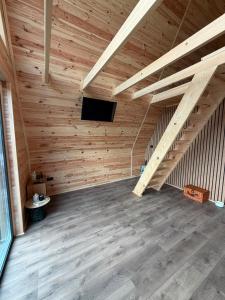 a wooden attic with a staircase and a tv at Vis de Munte Chalet in Buhalniţa